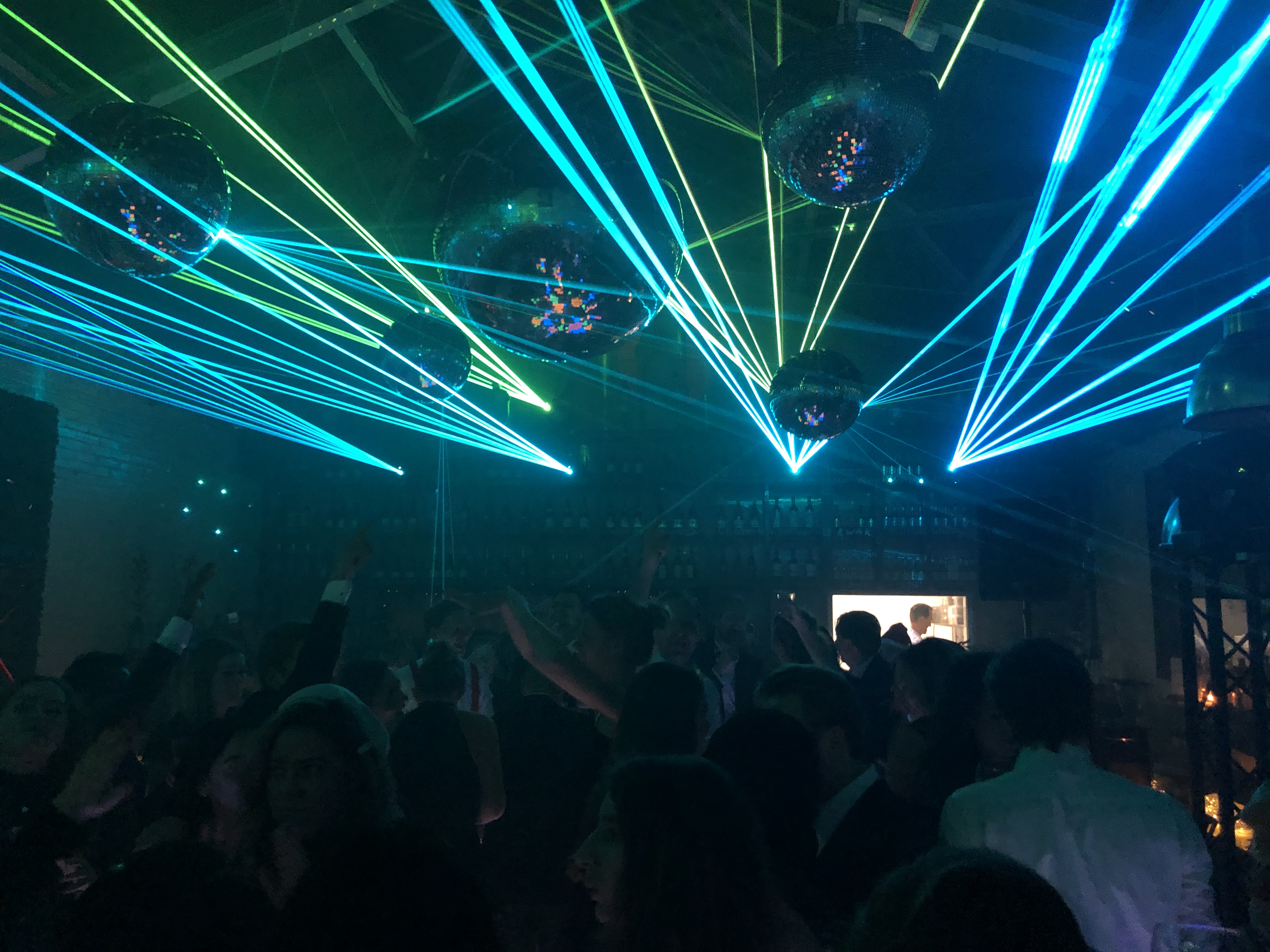 Foto van het event met veel lasers en discoballen
