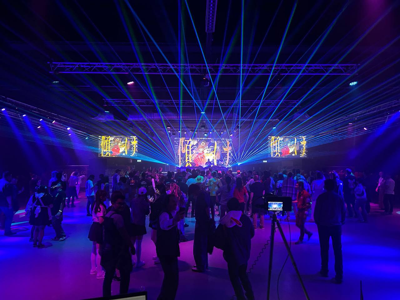 Foto van licht, lasers en geluid voor een volle zaal van dit evenement